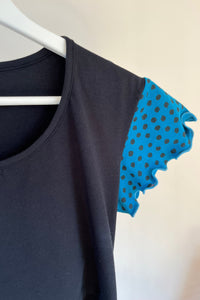 Black garment with blue polka dot trim on a white background
