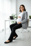 Pregnant woman sitting at a desk in an office setting