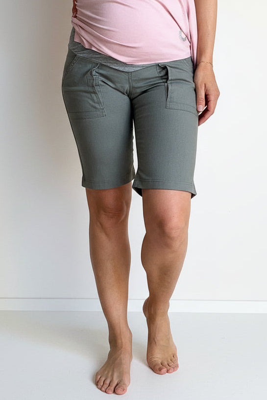 Person wearing green shorts and a pink top on a white background