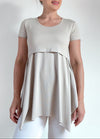 Woman wearing a beige tunic for maternity and breastfeeding  with a plain background